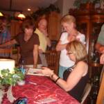 Sally Guilfoyle (DeSoto, KS) and Sheryl Whiteside Bloomfield (Ft. Scott)  enjoy looking over yearbook with Cindy Bartelsmeyer (John's wife).  Patrick Guilfoyle is looking over Shery's shoulder.